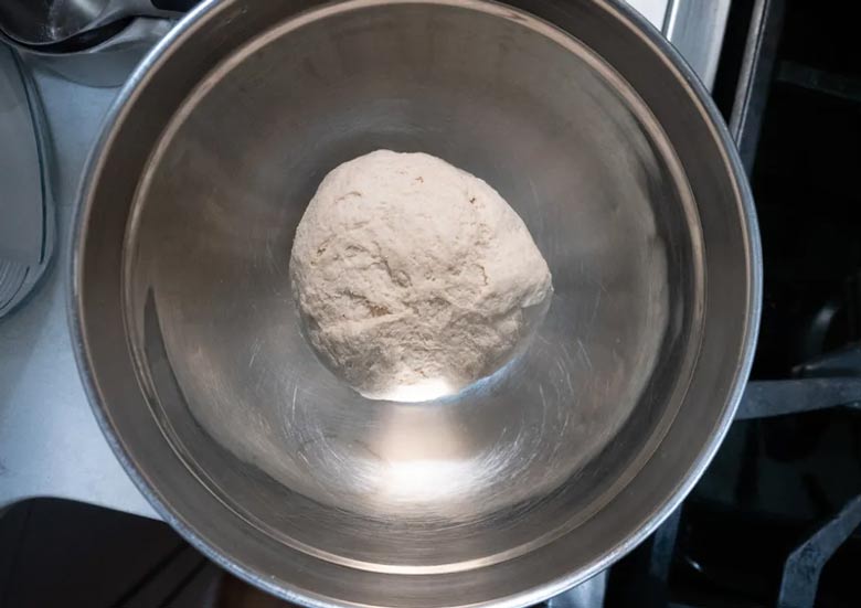 showering pizza dough in cold water