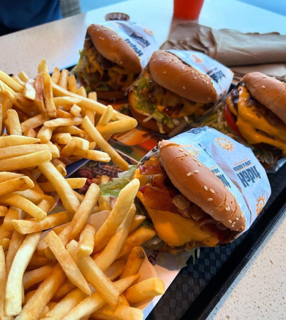 A tray filled with classic cheeseburgers and fries from the Habit menu with prices, showcasing a delicious and affordable meal option.