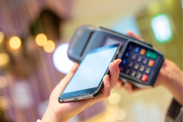 a phone is held near contactless reader for apple pay