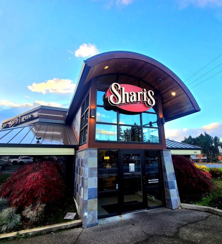 The entrance of Shari's Restaurant with its iconic sign under a clear blue sky, inviting customers to explore Shari's menu with prices.